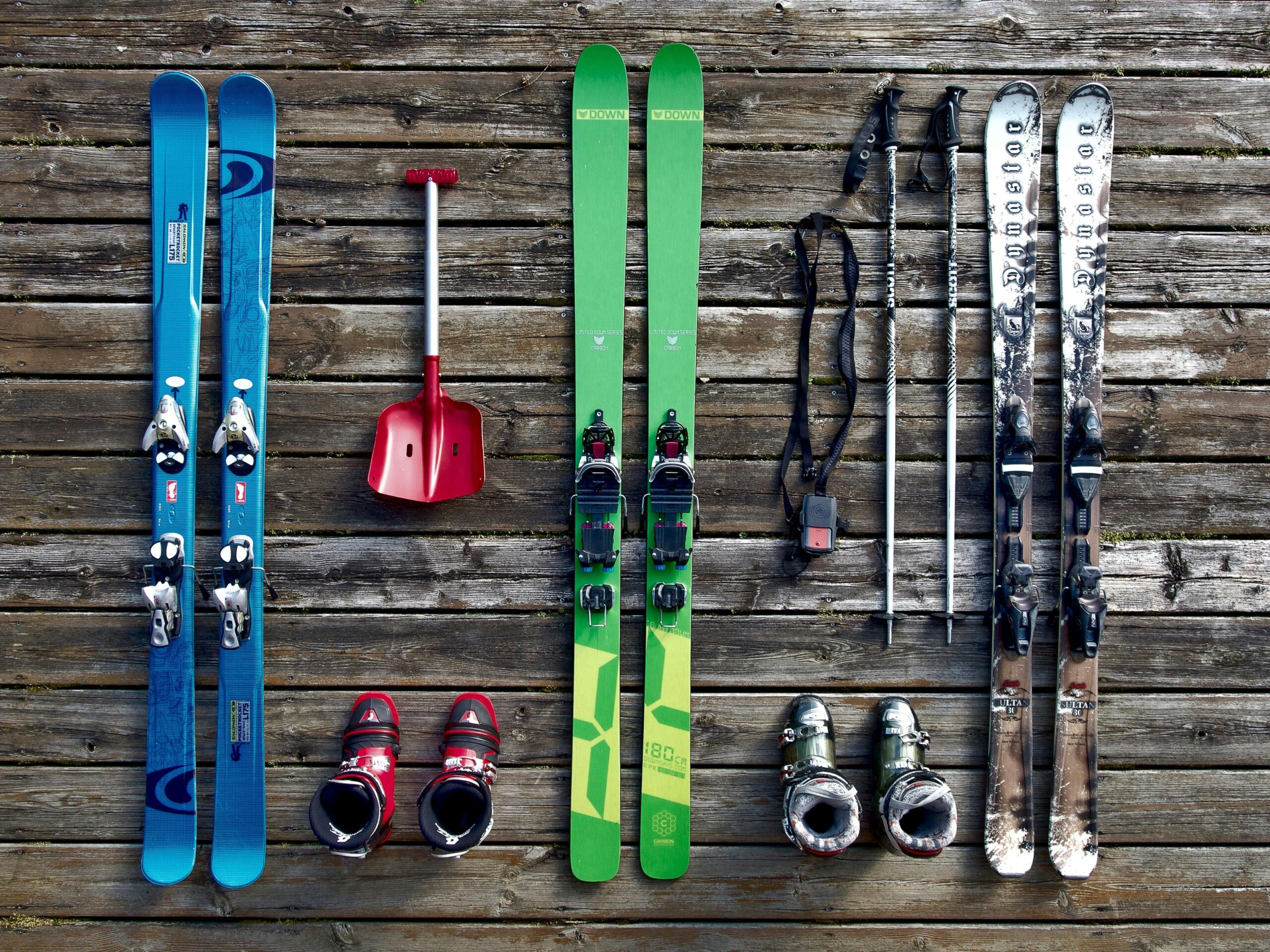 🔰新手滑雪選 Ski 還是 Snowboard?北海道滑雪完整指南 26 Collection of ski gear on a wooden deck, showcasing vibrant colors and vintage style.