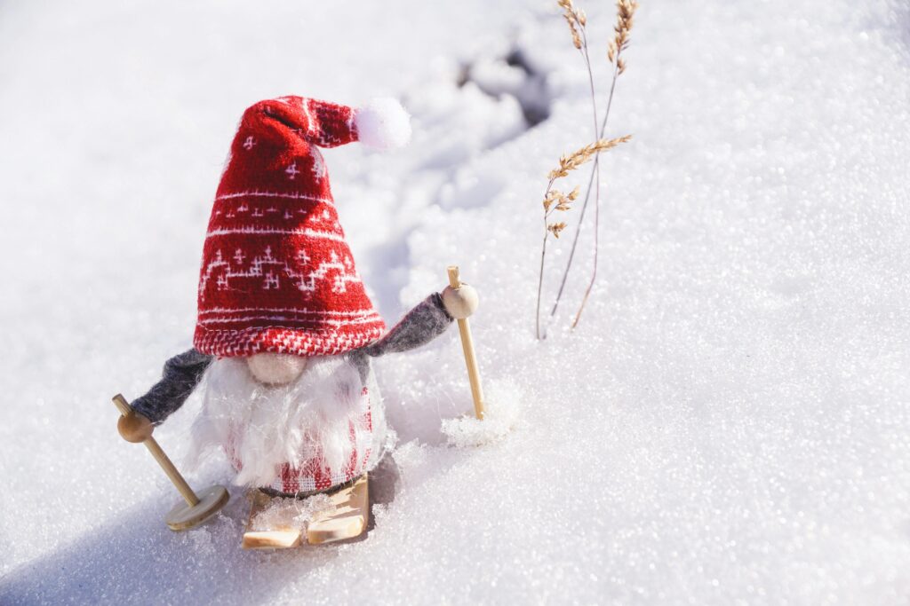Adorable gnome figurine skiing through fresh snow, capturing the essence of winter fun.
